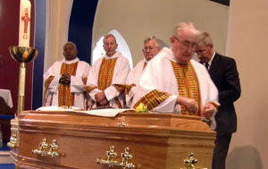 Bishop John Moore SMA blessing the coffin during the obsequies