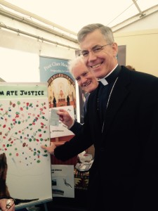 The Papal Nuncio  putting his Thumbprint on the Campaign sheet while Fr Maurice waits to give him the info sheet on how the Nuncio can make a positive change in his lifestyle to help our world.