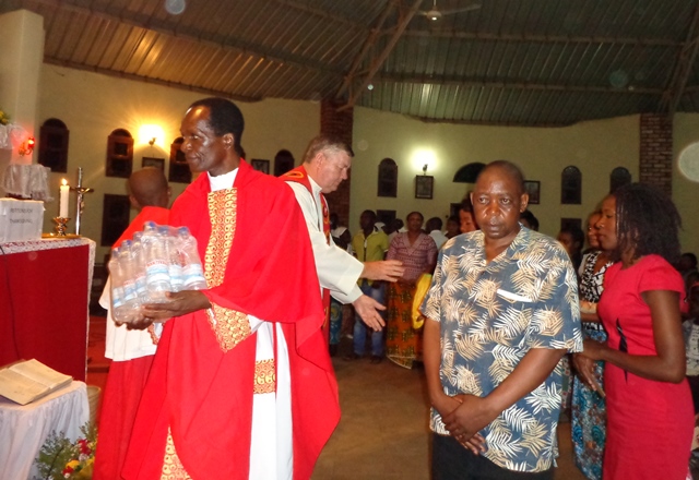 Fr Masimishila and Fr Barry receive gifts for the poor during the closing Mass